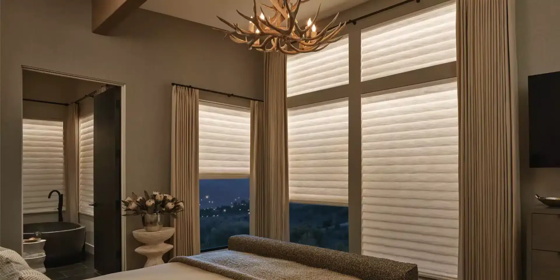 Modern luxury bedroom with large windows, elegant drapes, and sunset views.